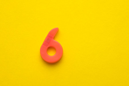 203679710-peach-colored-number-six-6-plastic-digit-on-yellow-foamy-background.jpg
