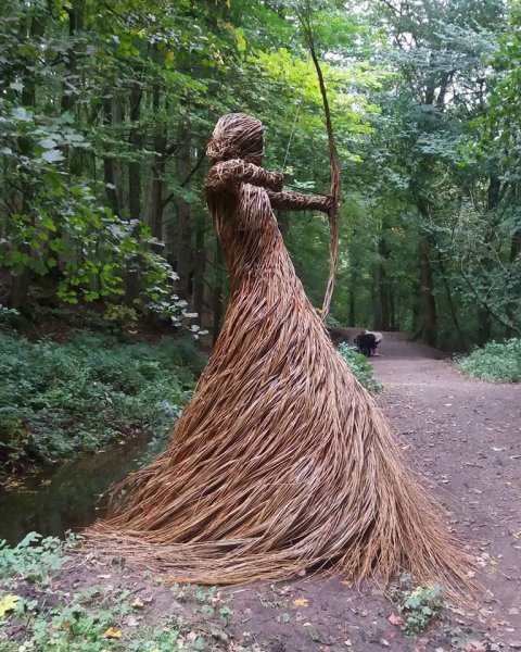 A huntress sculpture in the forest woven from willow branches.jpg